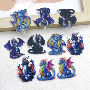 Flat lay of colorful acrylic dragon pendants for DIY jewelry making in various mythical styles
