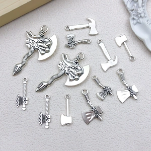 Detailed view of antique silver axe pendants with dragon relief on faux leather background