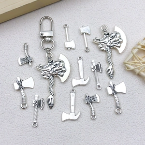 Macro view of vintage silver alloy axe pendants with detailed dragon head and tool patterns