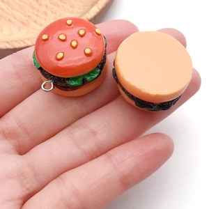 Macro view of realistic mini burger keychain pendants showing texture and silver metal rings