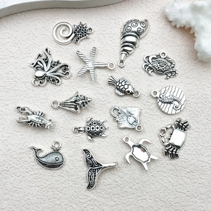Detailed macro of antique silver ocean charms featuring turtles and starfish pendants