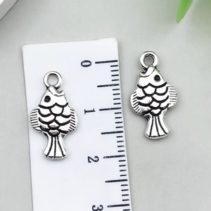 Detail of small fish pendants in antique silver with fine scales and hanging rings