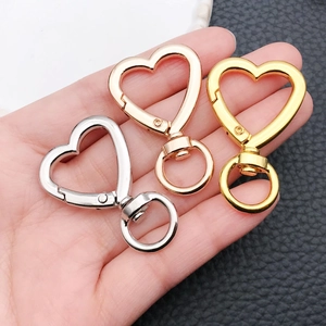Detalle de cierres de mosquetón con forma de corazón en acabados oro, plata y rosa