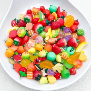 Vista detallada de dijes de frutas de resina de colores para crear joyas artesanales