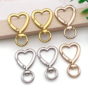 Detalle de mosquetones en forma de corazón en acabados oro, plata y oro rosa