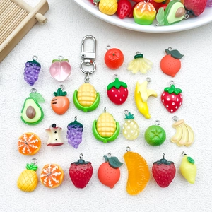 Vista plana de dijes de resina con forma de frutas coloridas para joyería artesanal