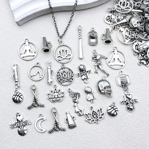 Detailed close-up of antique silver sports charms including basketball and soccer motifs