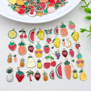 Gros plan de breloques émaillées en forme de fruits comme la fraise et la cerise
