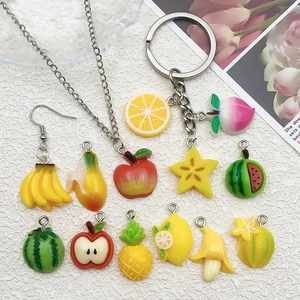 Macro shot of 3D resin fruit pendants with metal rings for DIY jewelry and crafts