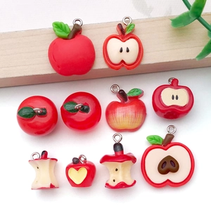 Vista detallada de colgantes de resina de manzana roja para joyería DIY con ganchos de metal