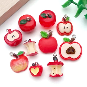 Detalle macro de colgantes de manzana de resina con semillas reales para crear joyas DIY