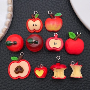 Vista detallada de diez colgantes de manzana en resina para creación de joyería DIY
