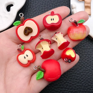 Detalle de colgantes de manzana en resina para DIY con anillas metálicas en varios estilos