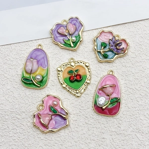 Vue détaillée de six pendentifs fleurs en émail coloré avec cadres en alliage doré