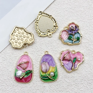 Vue détaillée de breloques florales en émail coloré avec placage or et perles