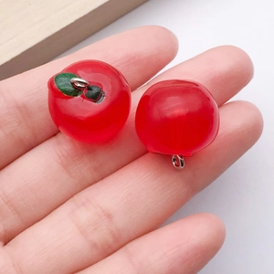 Detalle de un colgante de manzana roja 3D en resina con aro para crear bisutería