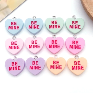 Macro detail of assorted pastel resin heart pendants with red BE MINE lettering
