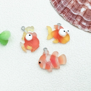 Macro shot of resin orange clownfish and goldfish pendants with metal jump rings