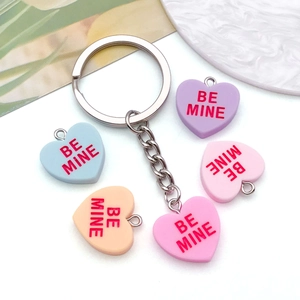 Detail of colorful resin heart pendants with BE MINE engraving and silver keychain link
