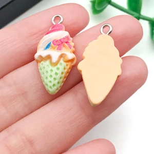 Close-up of DIY resin ice cream charm with pink cream, green cone, and metal loop