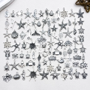 Detailed close-up of antique silver sea creature charms including starfish and seahorses