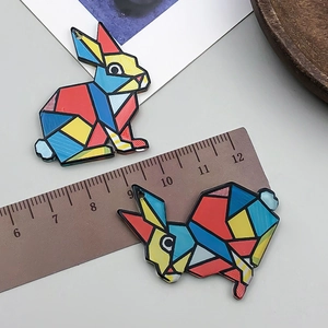 Makroansicht des bunten Acryl-Hasenanhängers mit Lineal zur Größenmessung im Detail
