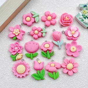 Flat lay of pink resin flower charms including roses and tulips with silver jump rings