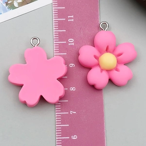 Detail of 2.5cm pink resin flower pendant showing front, back, and metal hanging ring