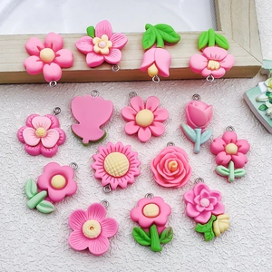 Pink resin flower pendants with metal rings for DIY jewelry making on white background