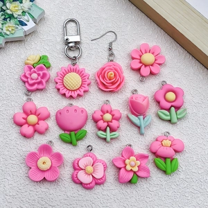 Flat lay of pink resin flower pendants including tulip and sunflower DIY jewelry charms