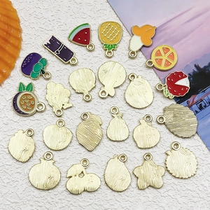 Detailed macro view of colorful enamel fruit charms with gold alloy backing for DIY jewelry