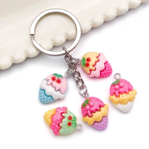 Porte-clés colorés en résine avec pendentifs glace et fraise sur une assiette de service