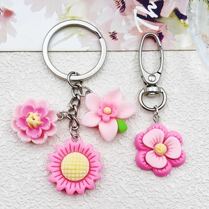 Detail of pink resin flower pendants with silver lobster clasps for DIY keychains
