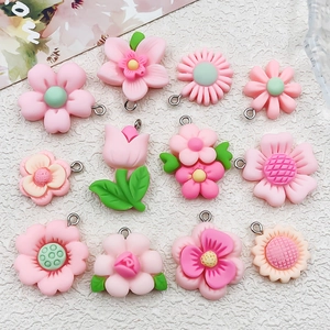 Flat lay of pink resin flower pendants with metal loops for DIY jewelry making