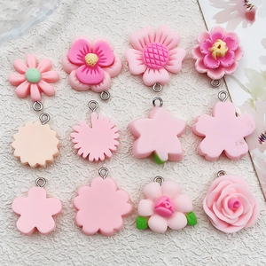 Flat lay of pink resin flower charms with metal loops for DIY jewelry making