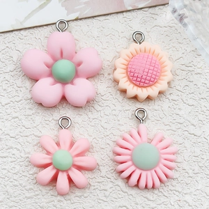 Close-up of pink resin flower pendants with metal loops for DIY jewelry making