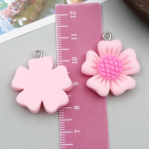 Pink resin flower charm with dark pink textured core and silver metal jump ring detail