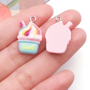 Primer plano de colgantes de resina de cupcake y helado con aros para joyería DIY