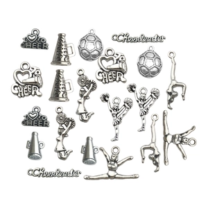 Macro view of antique silver cheerleader and gymnastics charms for DIY jewelry making
