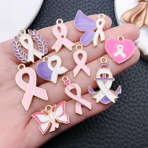 Macro shot of assorted pink and purple enamel awareness ribbon charms with gold-plated edges