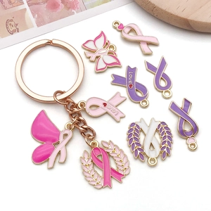 Detail of pink enamel breast cancer awareness charms with rose gold finish and ribbon motifs