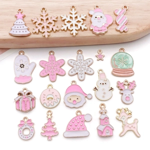 Detailed view of pink and white enamel Christmas charms with golden frames for DIY jewelry