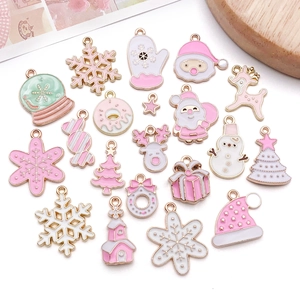Flat lay of pink and white Christmas charms for DIY jewelry making with gold metal edges