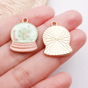 Detail showing green enamel snowflake ball charms for DIY jewelry making with gold base