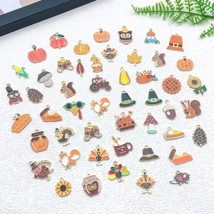 Vista plana de dijes de esmalte otoñales coloridos con calabazas, pavos y arces