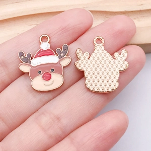 Detail of Christmas reindeer charm with red enamel hat and gold textured back for DIY jewelry