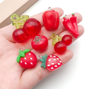 Assorted red resin fruit and vegetable charms including cherry, strawberry, and chili