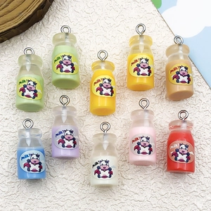 Detailed close-up of colorful DIY resin milk bottle pendants with cute cow stickers