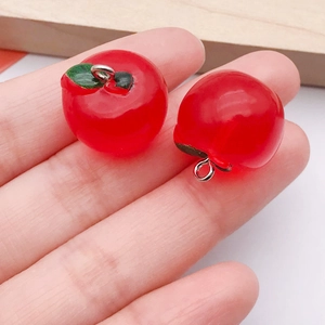 Detail shot of mini resin apple charms with green leaves for DIY jewelry making