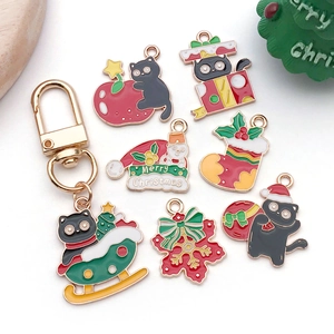 Vue à plat de pendentifs de Noël en émail avec chat noir, flocon de neige et bonnet de Noël